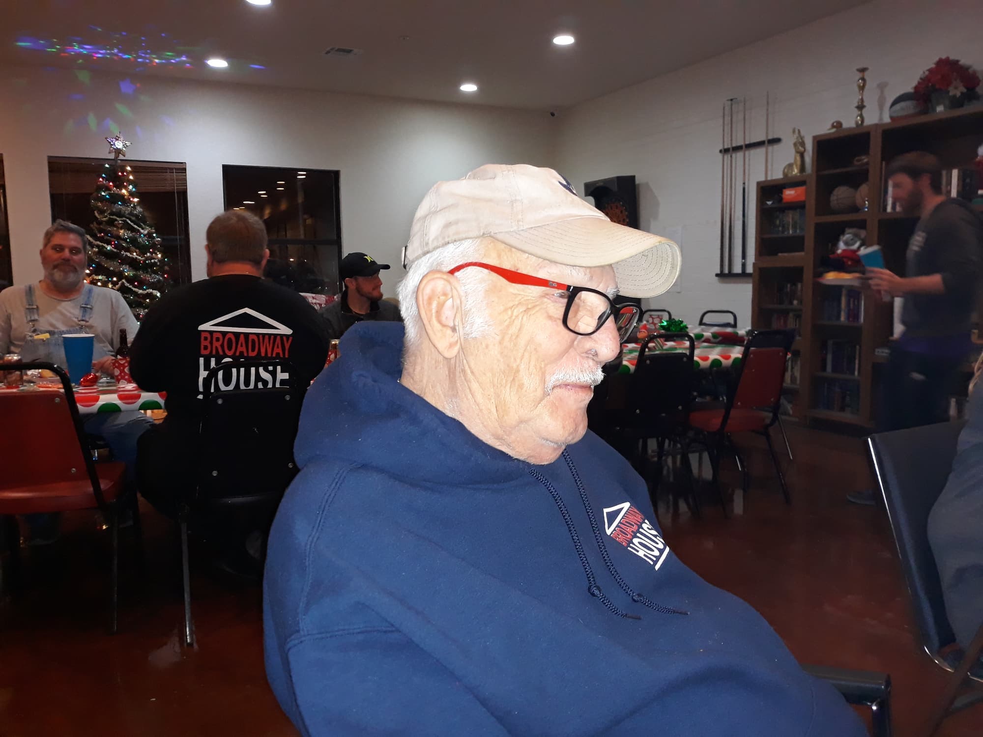 An older gentleman in a Broadway House hoodie at the holiday dinner