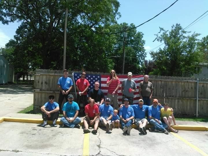 The Broadway House team posed in a group photo outdoors with an American flag behind them