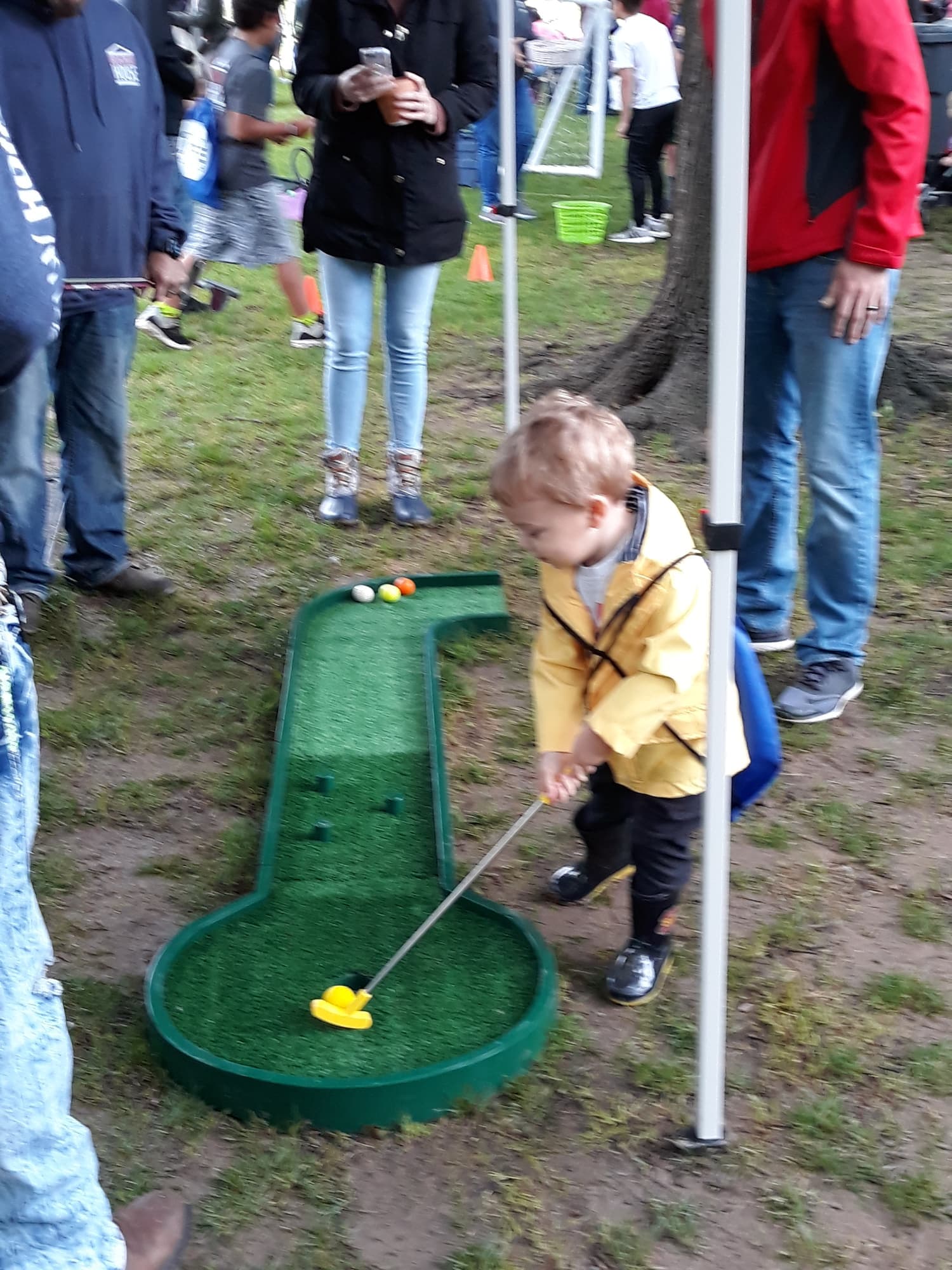 A child lining up a putt on the mini golf hole